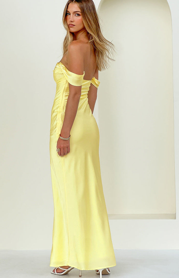 Side view of a light yellow off-shoulder maxi dress with a sweetheart neckline and ruched detail at the waist