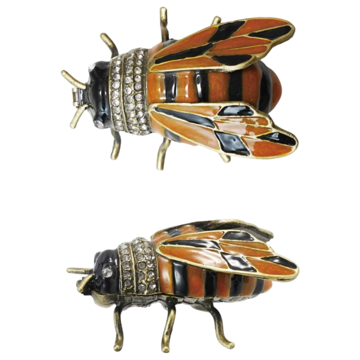 Two bee-shaped pins with rhinestone details on a white background