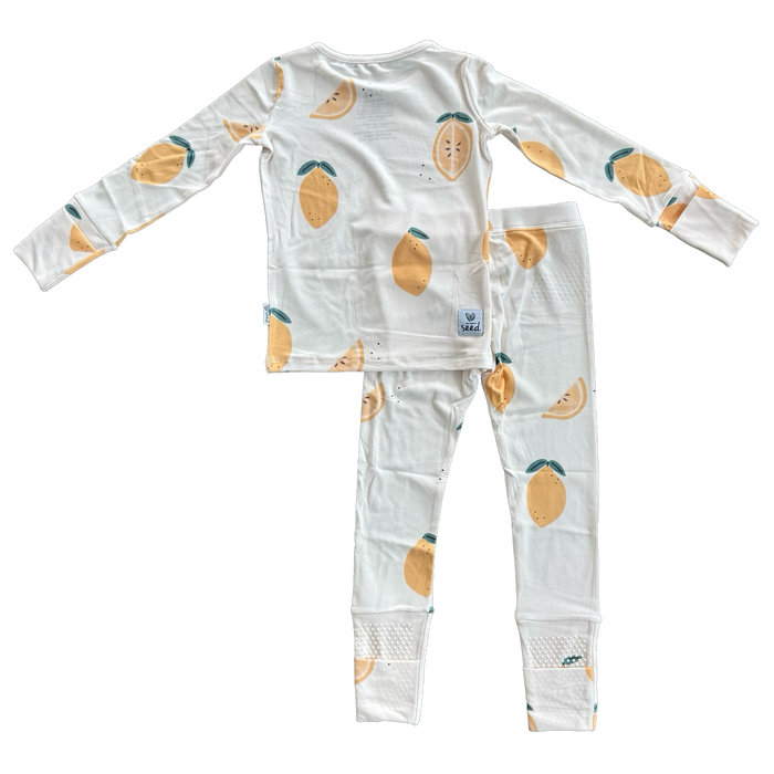 A two-piece children's pajama set consisting of a long-sleeve top and matching pants, printed with a pattern of yellow mangoes with green leaves on a white background.