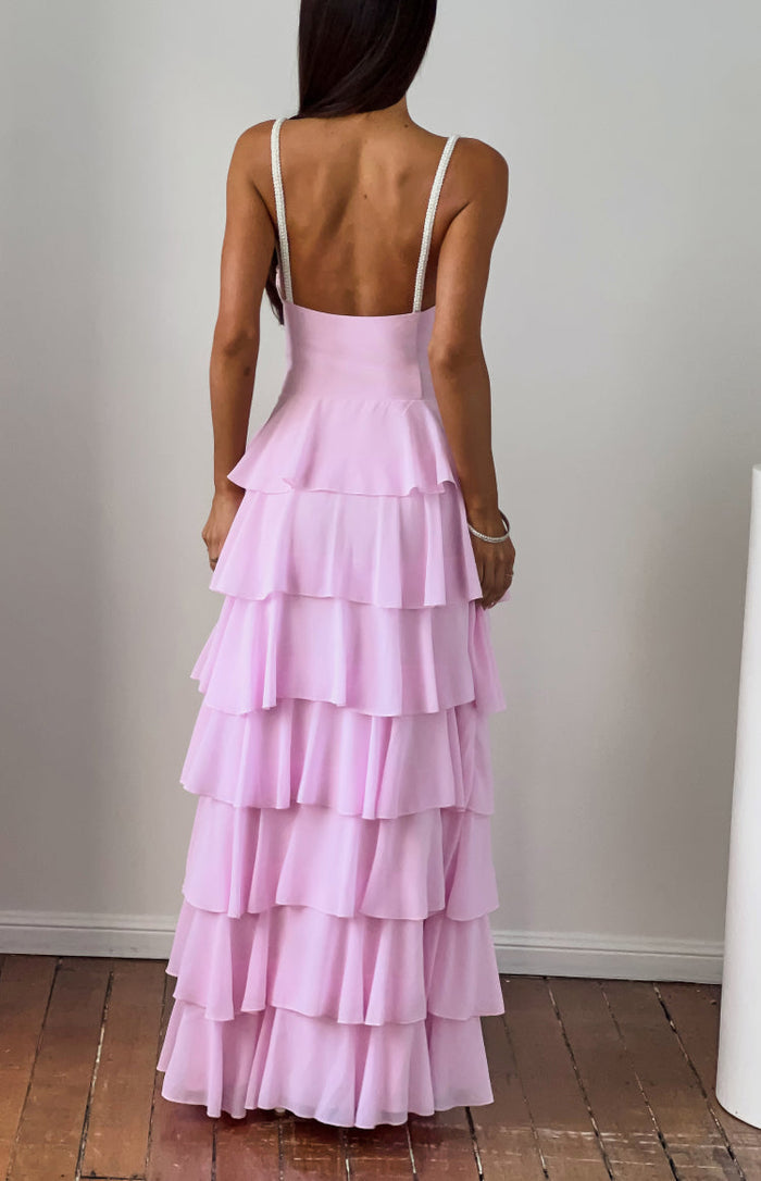Rear view of a pink tiered ruffle maxi dress with pearl spaghetti straps and a low scoop back