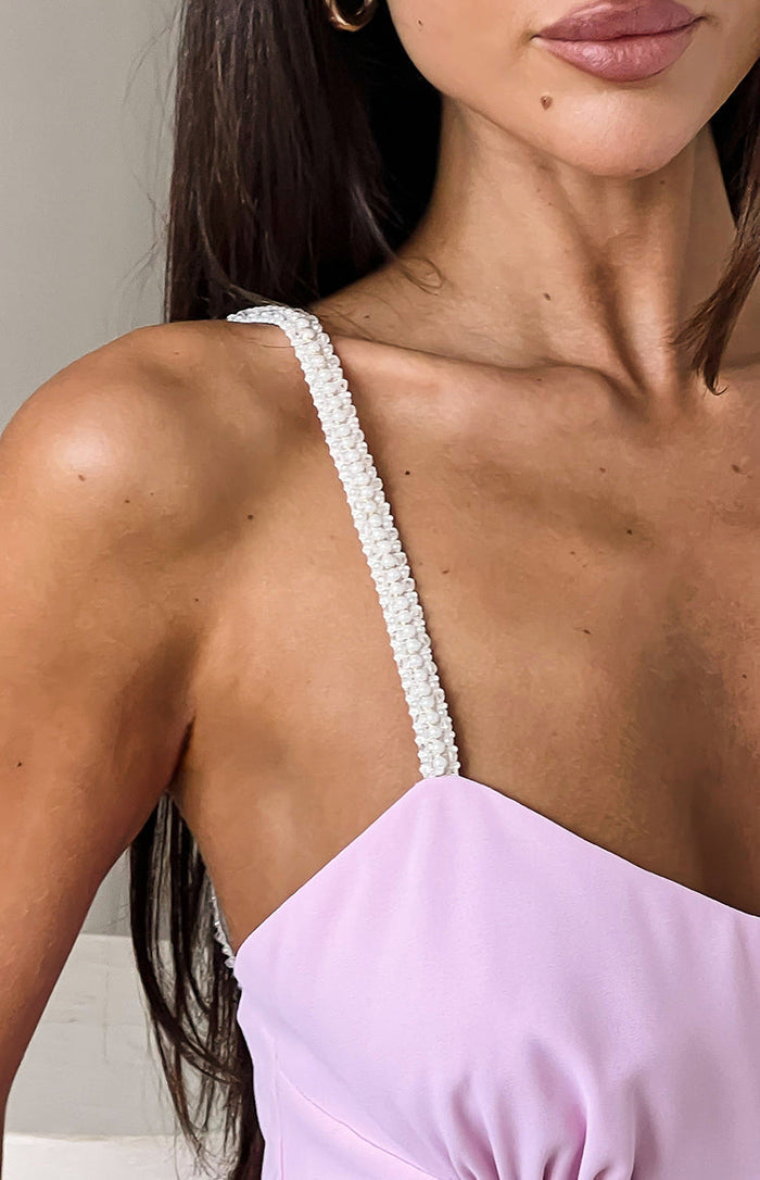 Close-up of the white pearl-embellished strap on a pink maxi dress
