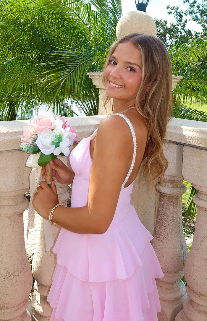 Pink maxi dress with pearl spaghetti straps and a full tiered ruffle skirt