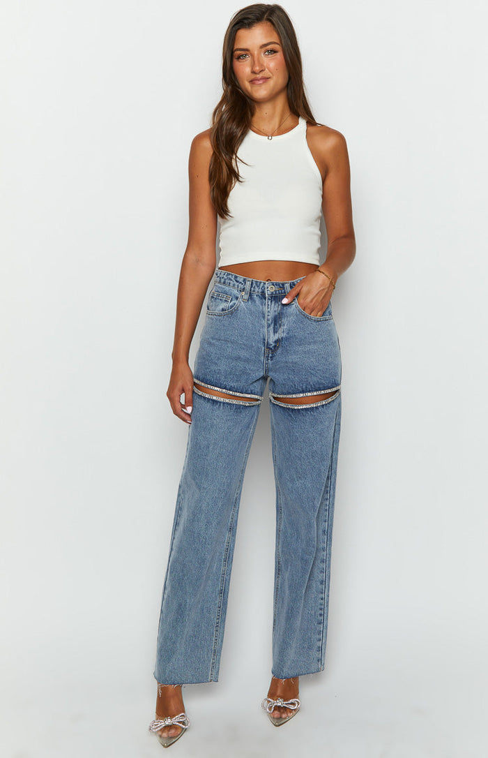 Front view of light blue wide leg denim jeans with diamante trim cutouts on the upper thighs