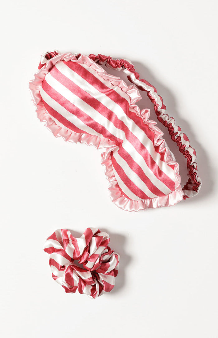 Red and white striped satin eye mask with ruffled pink edges, paired with a matching scrunchie
