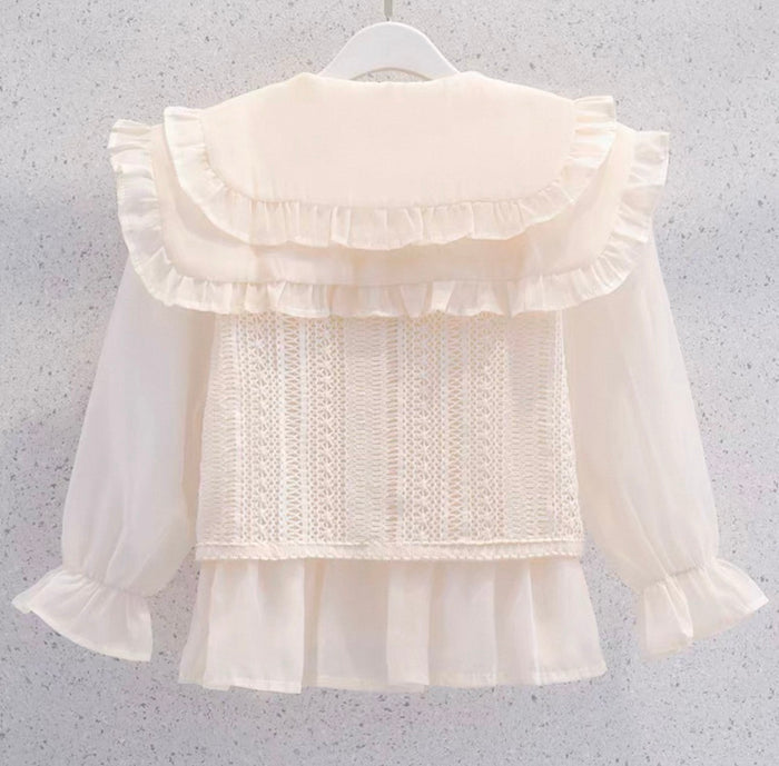 White blouse with ruffled details on a gray background
