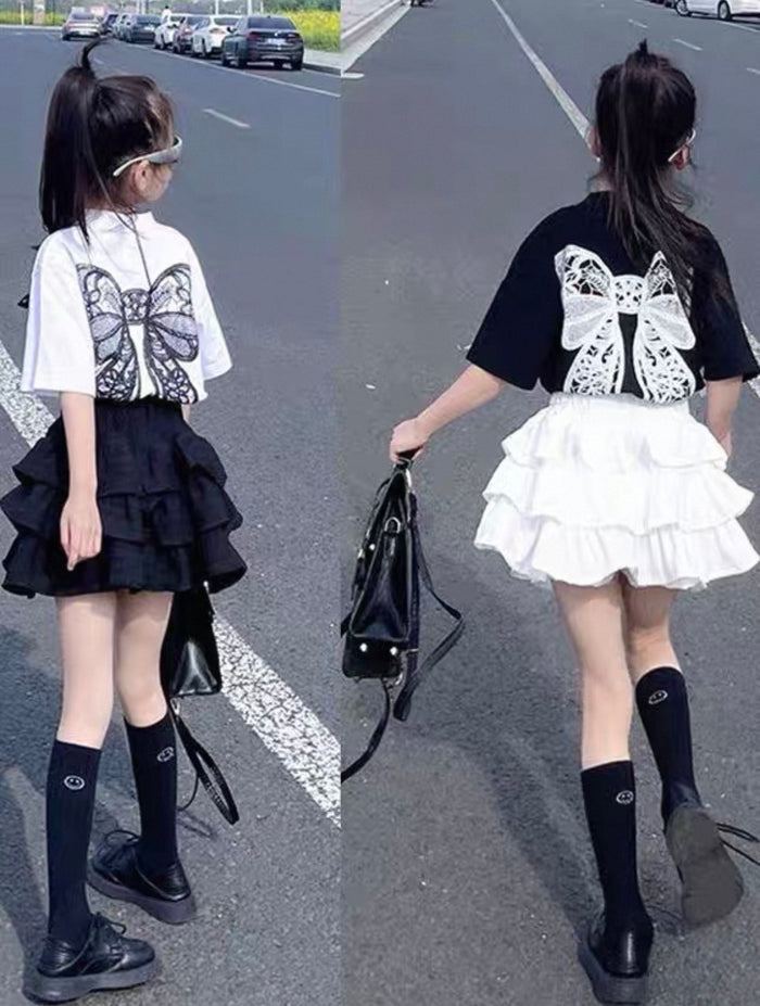 Two images of a person wearing a black and white outfit with butterfly design on a road.