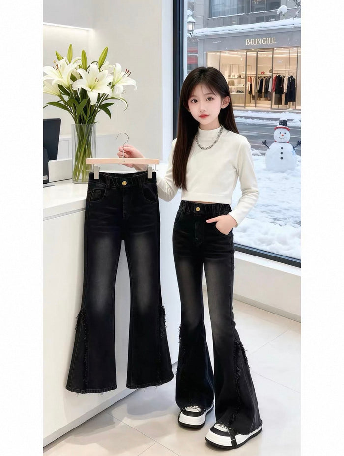 Woman wearing black flared jeans and a white top in a store setting.