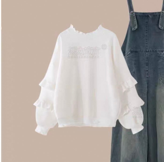White blouse with ruffled sleeves and denim overalls on a beige background