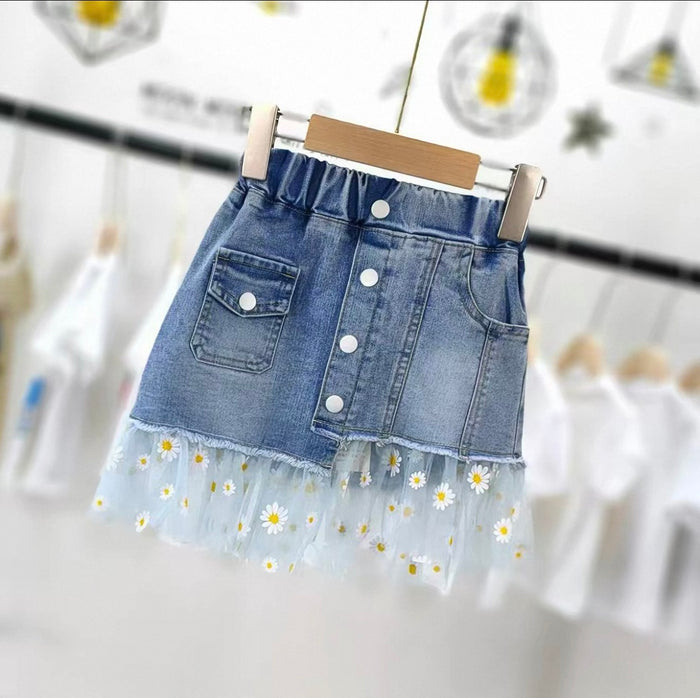 Denim skirt with floral hem on a hanger against a blurred background