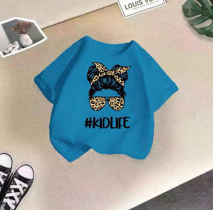 Blue t-shirt with '#KIDLIFE' design on a textured surface