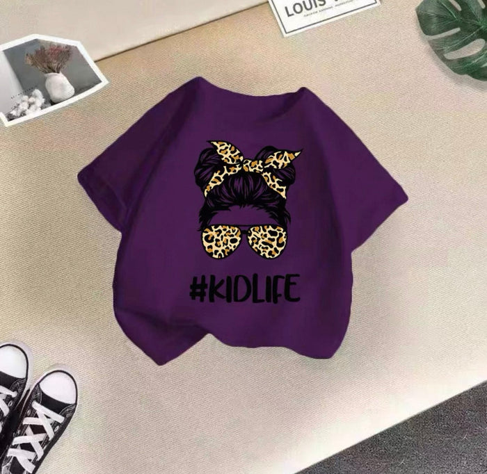 Purple sweatshirt with leopard print hair bun and sunglasses design, featuring '#KIDLIFE' text, on a textured surface.