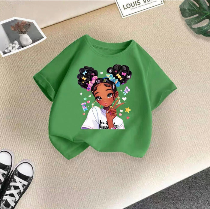 Green t-shirt with a graphic of a girl with braids and colorful accessories on a beige surface.