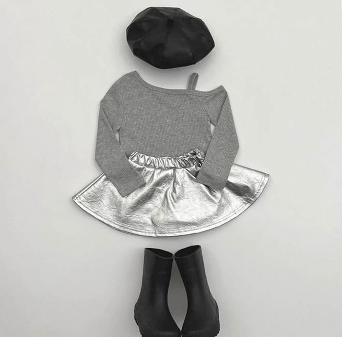 Gray long-sleeve top with silver skirt, black beret, and black ankle boots on a light gray background