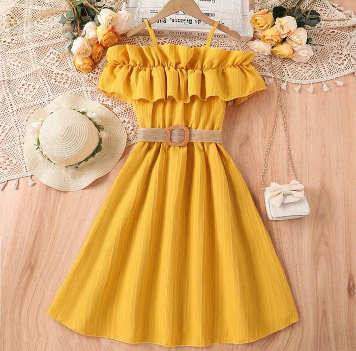 Yellow dress with a hat and handbag on a wooden surface