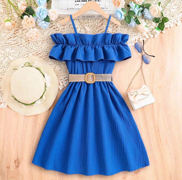 Blue dress with ruffled top and belt on a wooden surface with decorative items.