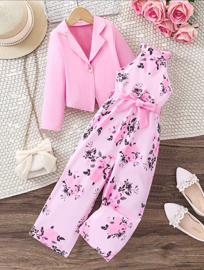 Pink floral outfit with matching jacket on a wooden surface with decorative items.