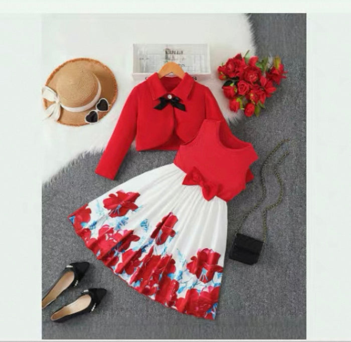 Red top and floral skirt set with accessories on a gray surface