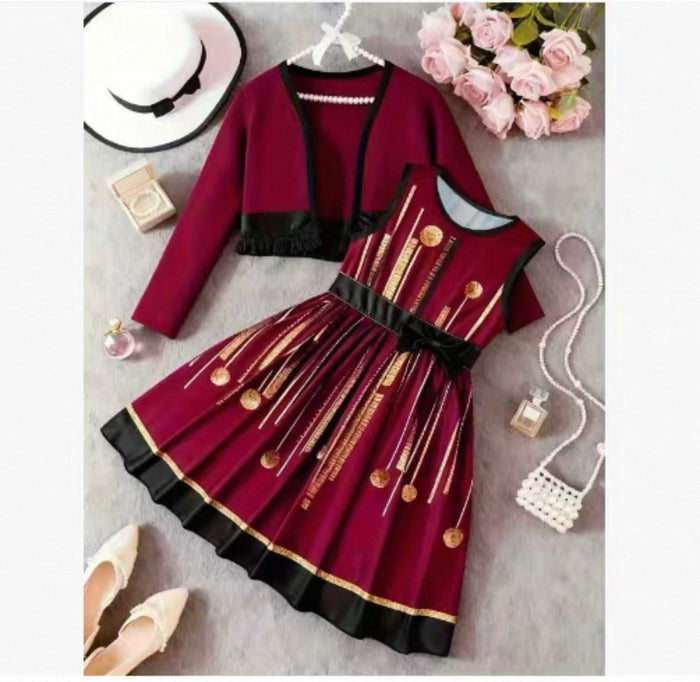 Red dress with gold accents on a gray surface with accessories.