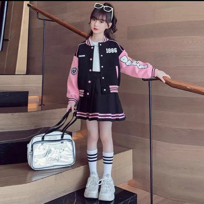 Person wearing a black and pink varsity jacket with a white bag on a wooden staircase.