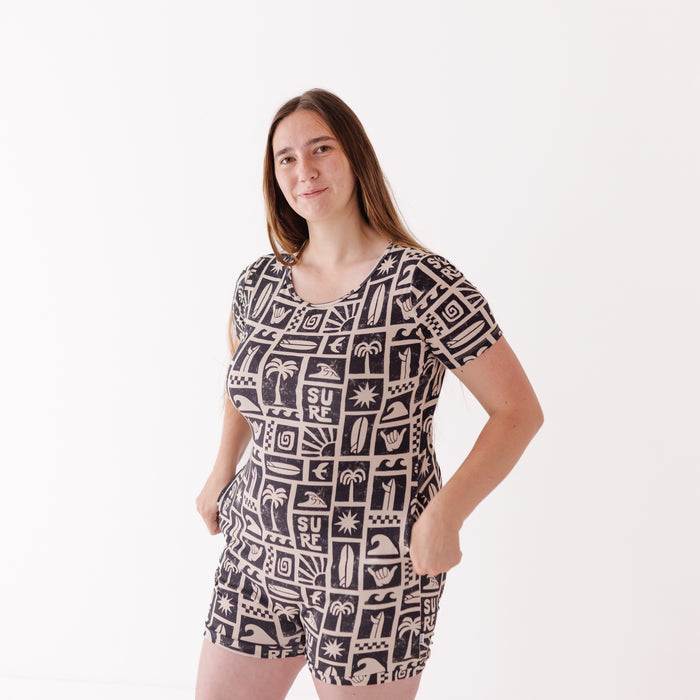 Woman wearing a black and white patterned romper on a white background