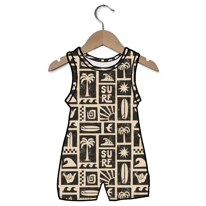 Children's sleeveless romper with surf-themed patterns on a hanger against a white background