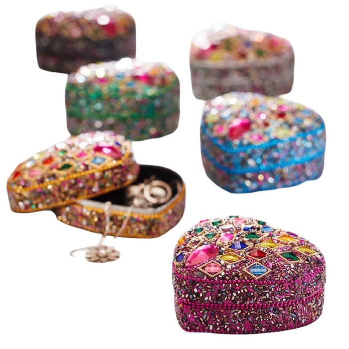 Five heart-shaped beaded jewelry boxes in different colors, decorated with colorful rhinestones and one open box showing rings inside, on a plain white background.