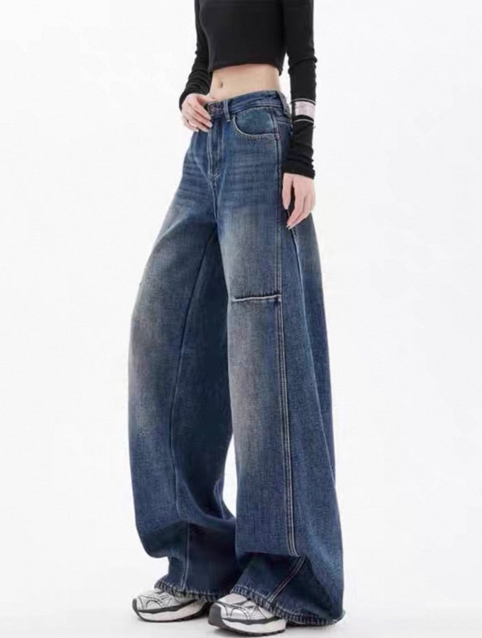 Person wearing wide-leg blue jeans on a white background