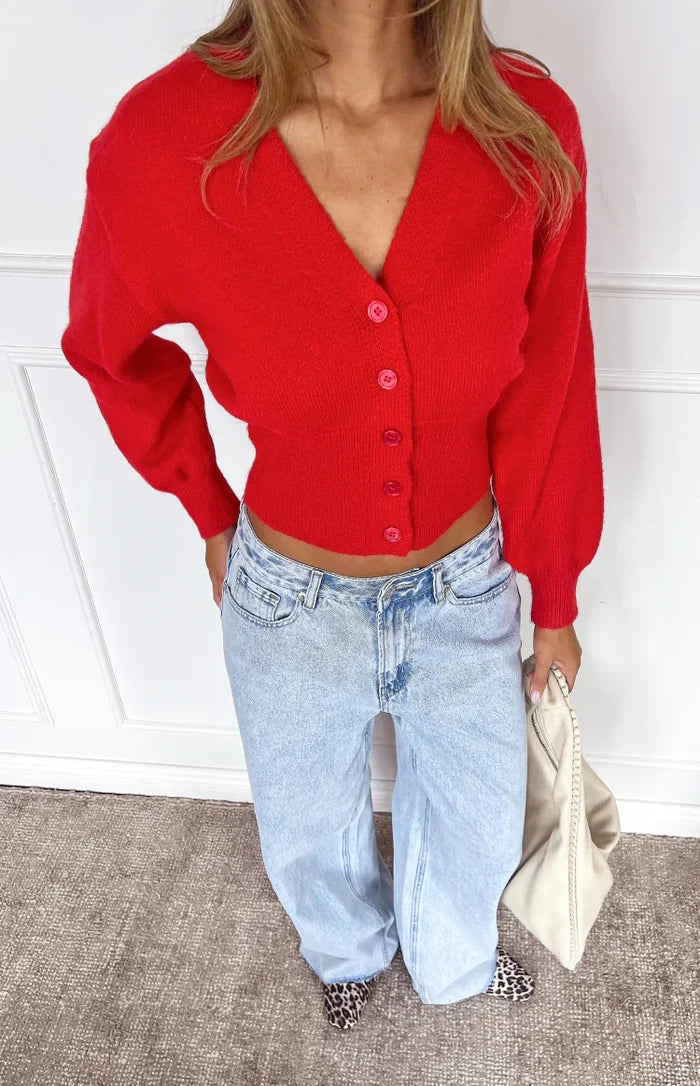 Red knit oversized cardigan with a deep V-neck, long puff sleeves, and a cropped ribbed hem