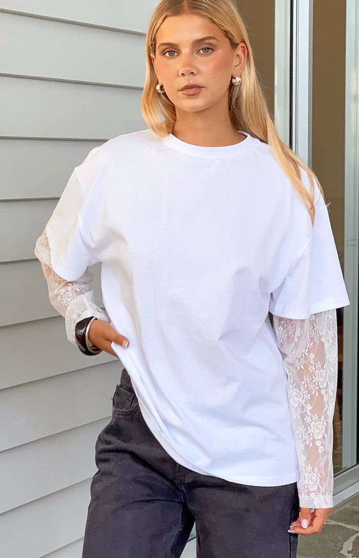 White long sleeve tee with sheer floral lace sleeves, layered under a short sleeve tee