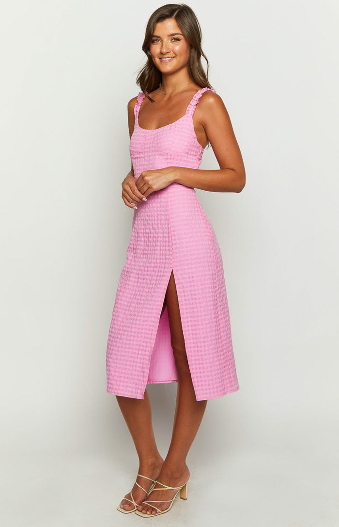 Side view of a pink gingham midi dress with ruffled shoulder straps and a high side split