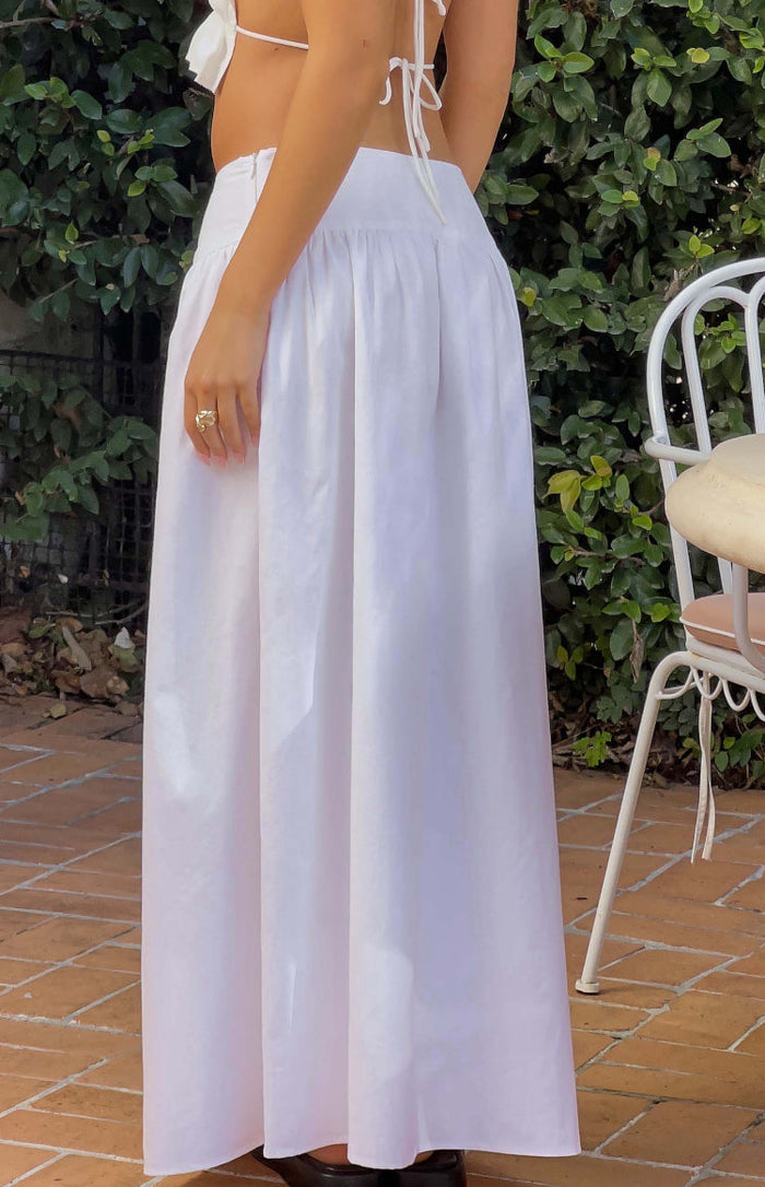 Side view of a white maxi skirt with a gathered high waist and a long, flowing silhouette