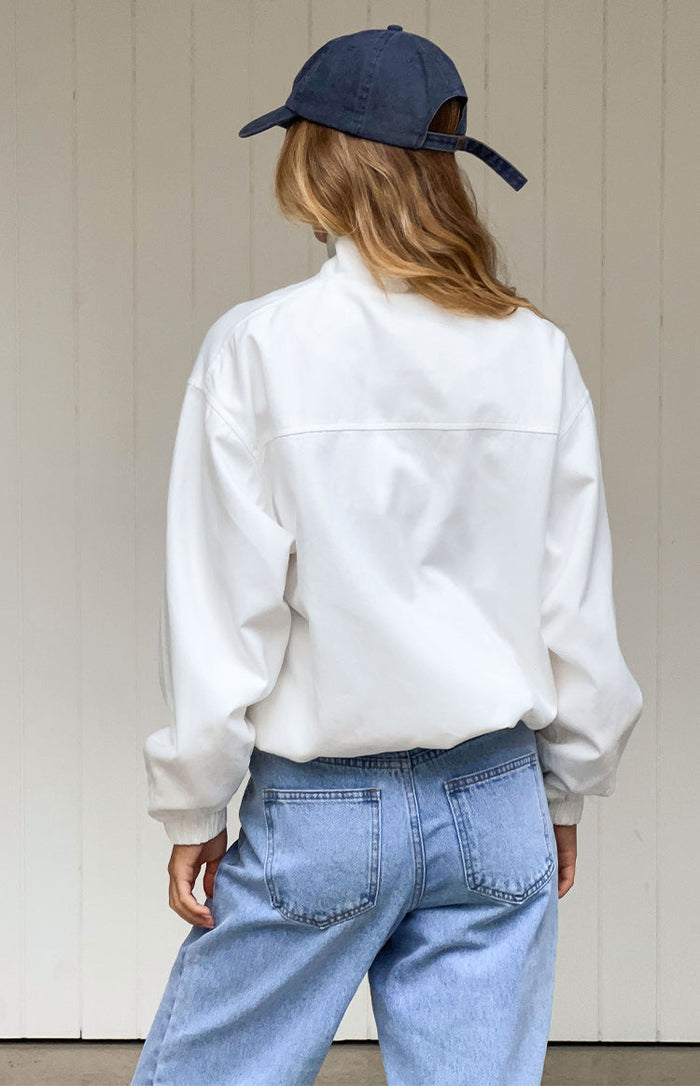 Rear view of a cream funnel neck jacket with a horizontal seam across the upper back and elasticated hem