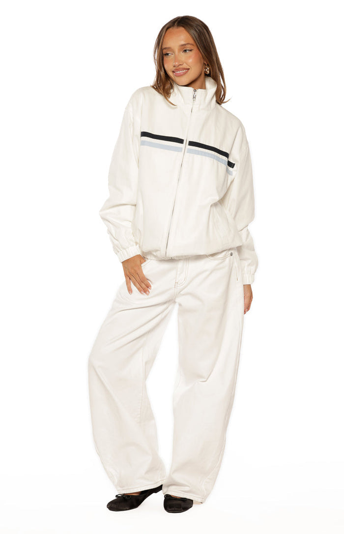 Front view of a cream funnel neck jacket with black and light blue chest stripes and elasticated hem