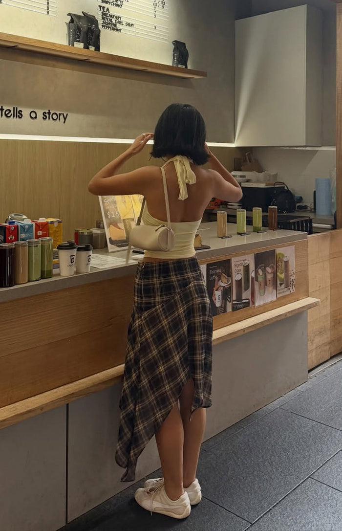 Rear view of a dark blue and brown plaid midi skirt, highlighting the asymmetrical hanky hem