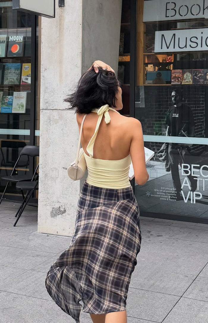 Rear view showing the flowing hanky hem and blue plaid pattern of a midi skirt