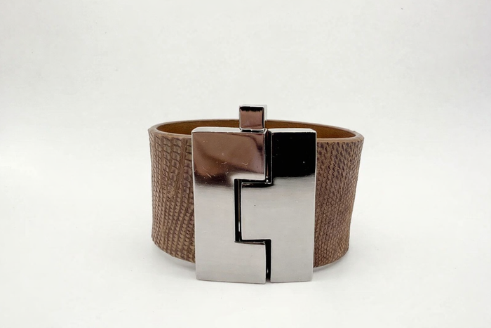 Brown leather bracelet with a silver geometric clasp on a white background