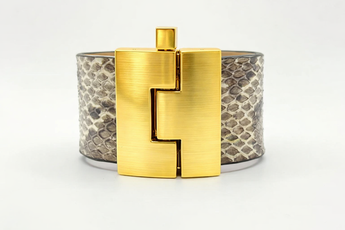 Gold bracelet with a unique clasp design on a white background