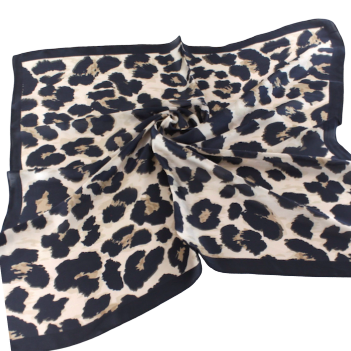 Square scarf with black leopard spots on a warm cream background and a solid black border.