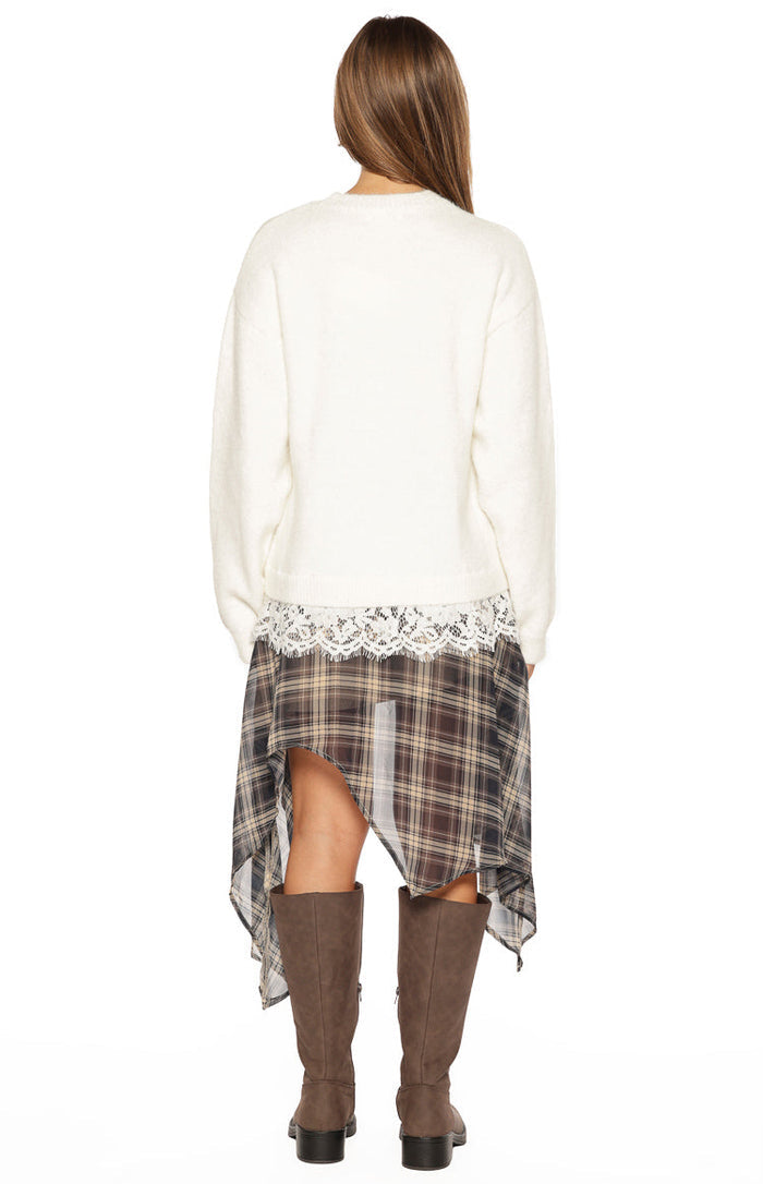 Rear view of the cream knit with a round neckline and white lace trim peeking out from the hem