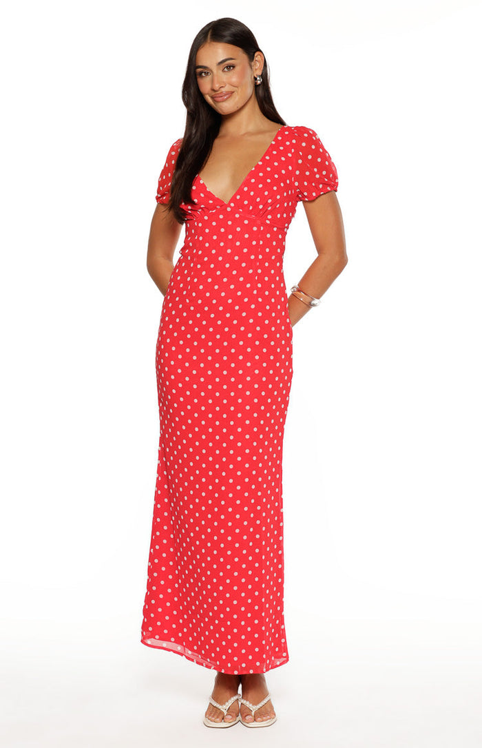 Front view of a red polka dot maxi dress with a deep V-neck and short puff sleeves