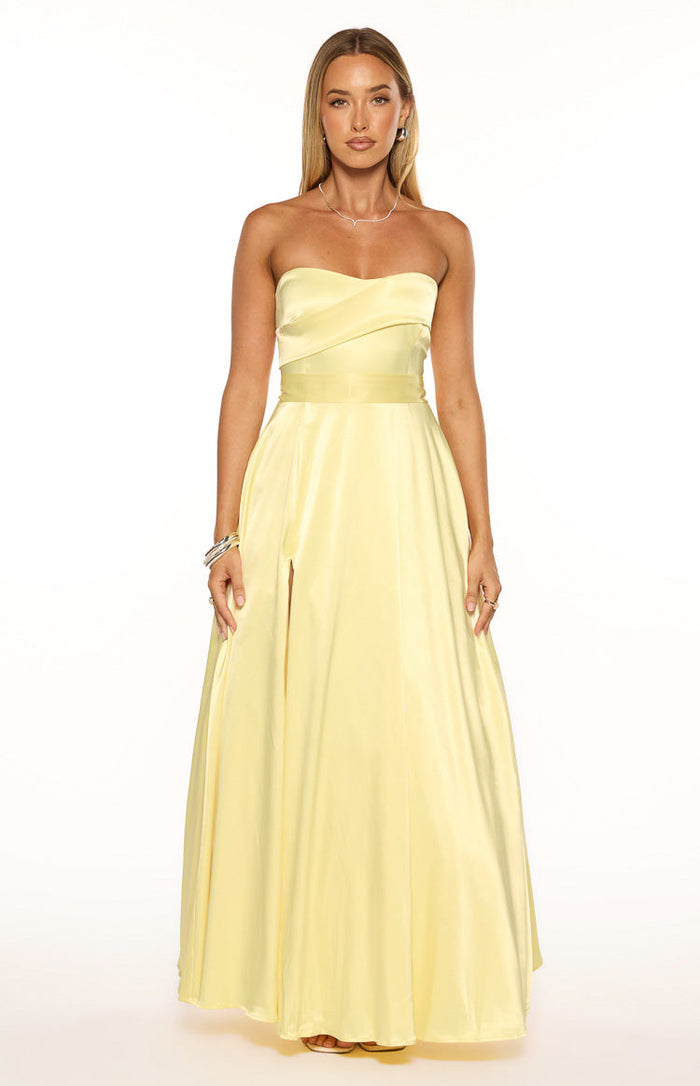 Front view of a yellow satin strapless maxi dress with a ruched bodice, a wide waistband, and a high leg slit
