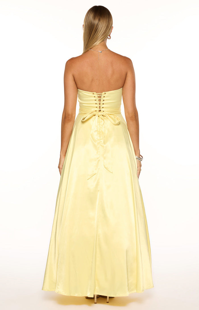 Rear view of a yellow satin maxi dress with a lace-up corset back and a tie-back bow