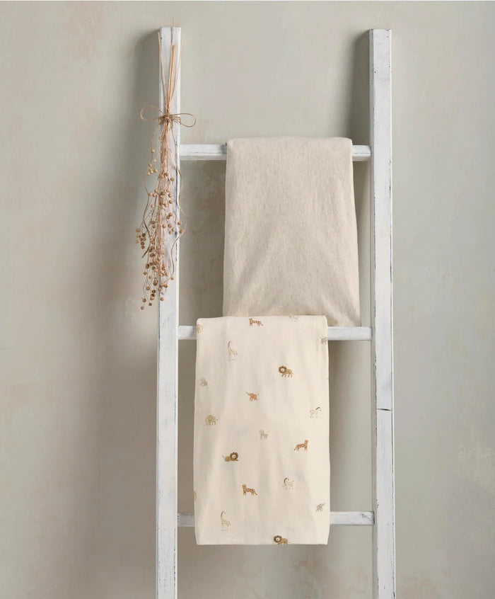 White decorative ladder with folded blankets for wild safari and marl fitted sheets setup