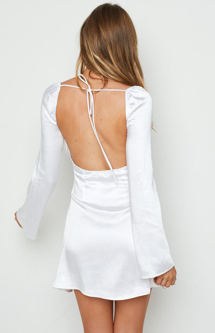 Rear view of a white satin mini dress with a low scoop back, tie-up straps, and long bell sleeves
