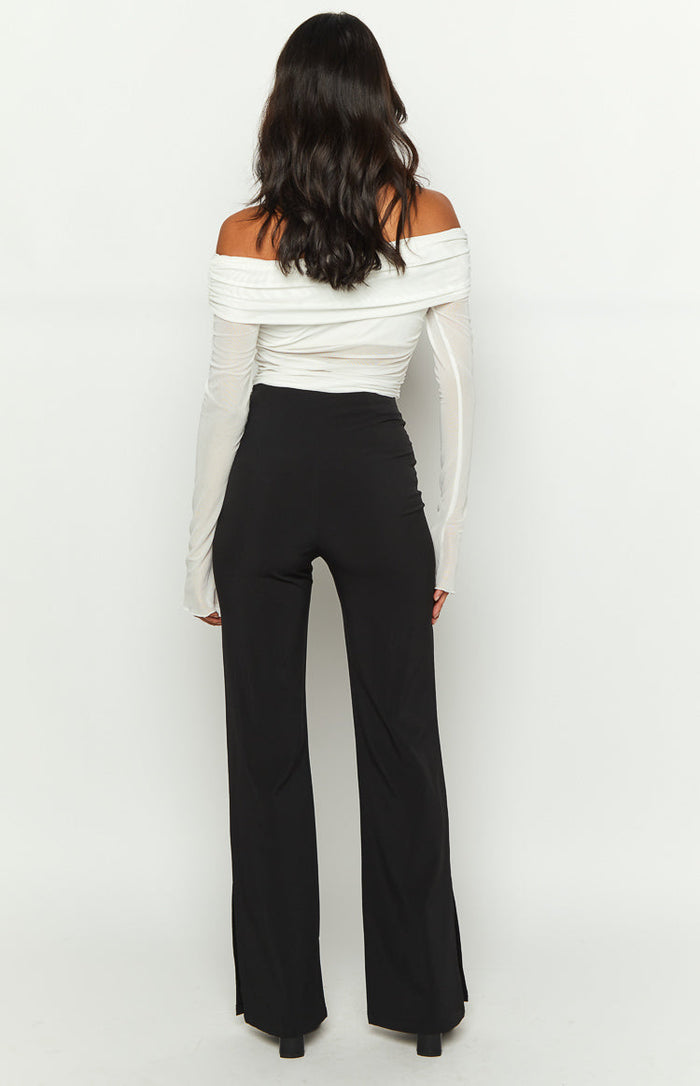Close-up of the fitted hip and thigh of black pants with a subtle front seam