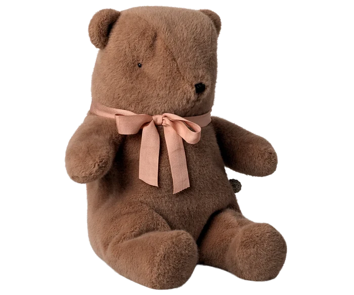 Brown teddy bear with a pink bow on a white background