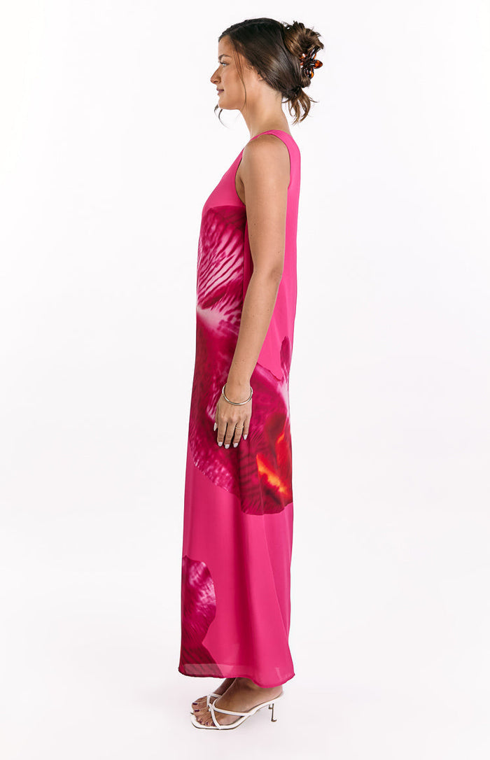 Side view of a pink orchid print maxi dress with a relaxed, flowy silhouette and sleeveless design