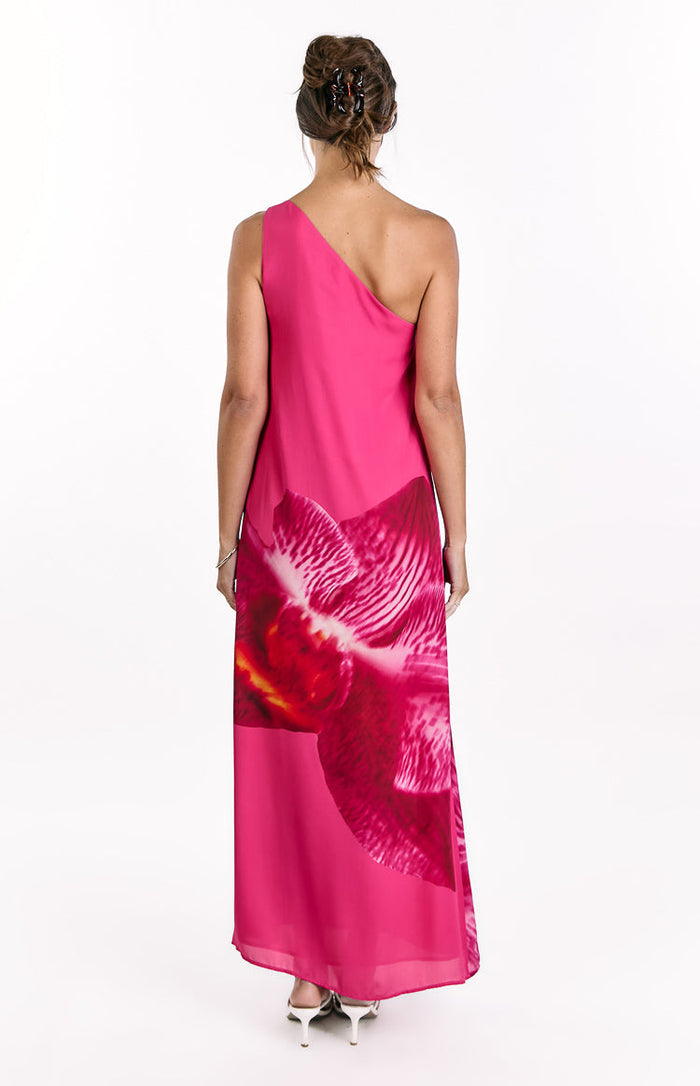 Rear view of a pink one-shoulder maxi dress with a large orchid print on the skirt