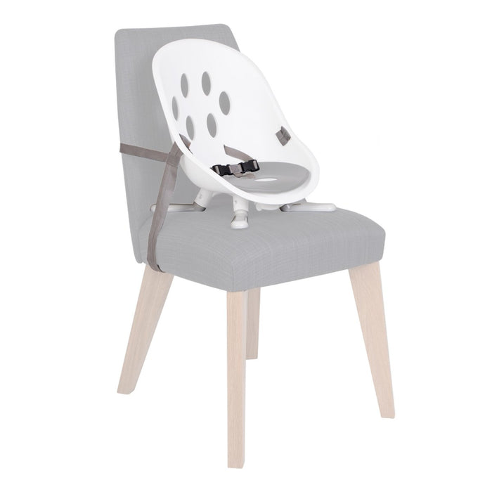 White and gray booster seat attached to a gray chair in Phil&Teds poppy modes kit scene
