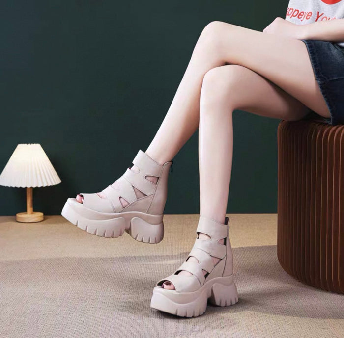 Person wearing pink platform sandals sitting on a stool with a dark background